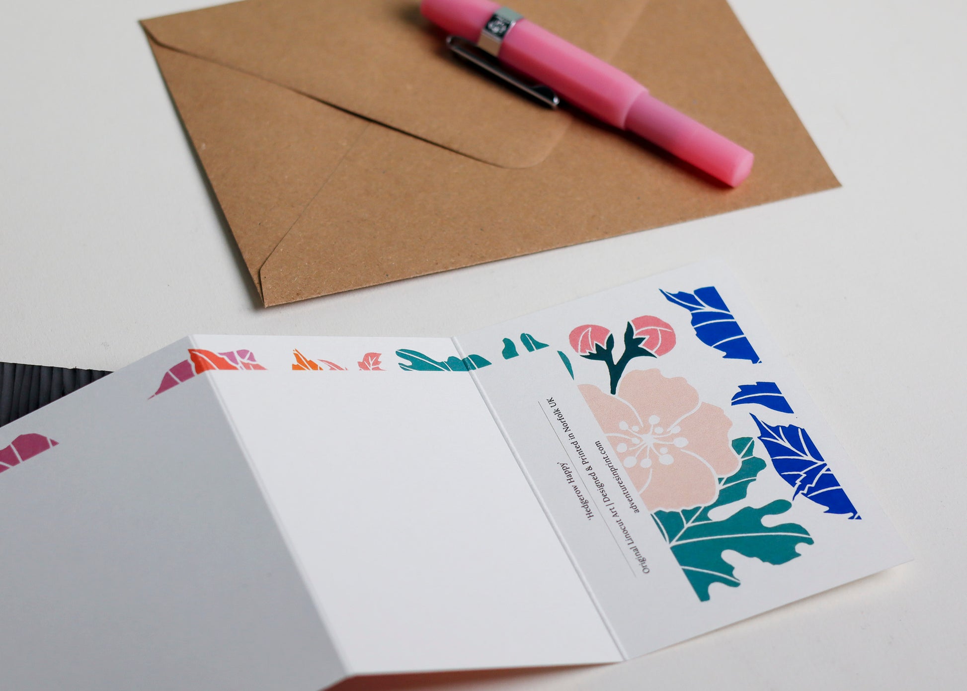 Happy Hedgerow Garland card with C6 kraft envelope. Hand-carved botanical portrait greeting card on recycled cardstock, photographed with eco-friendly envelope, ready for posting.
