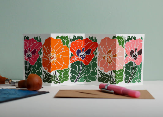 Poppy Parade Garland card featuring hand-carved linocut botanical portrait in pink, orange and red. Double-sided concertina greeting card with bold, contemporary cottagecore design on eco-friendly recycled cardstock.