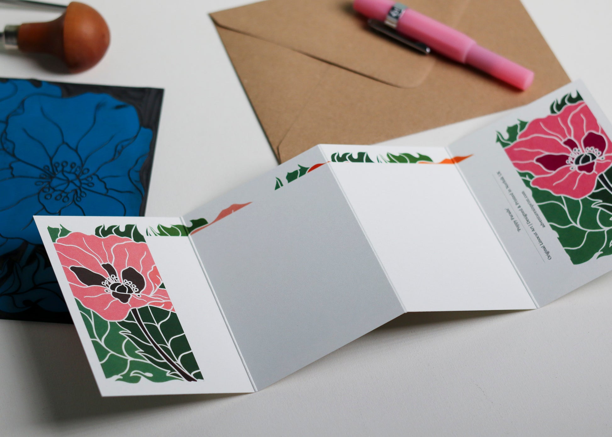 Poppy Parade Garland card with C6 kraft envelope. Hand-carved botanical portrait greeting card on recycled cardstock, photographed with eco-friendly envelope, ready for posting.