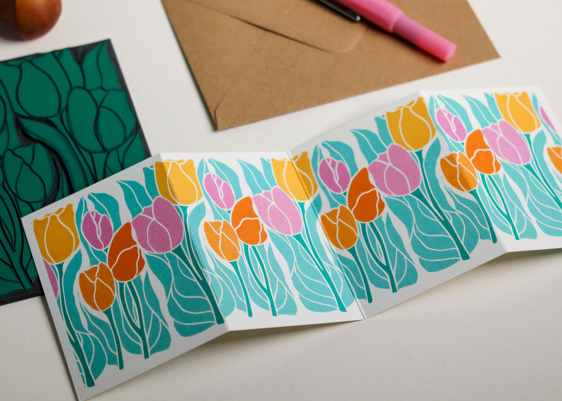 Spring tulip Garland card with C6 kraft envelope. Hand-carved botanical portrait greeting card on recycled cardstock, photographed with eco-friendly envelope, ready for posting.