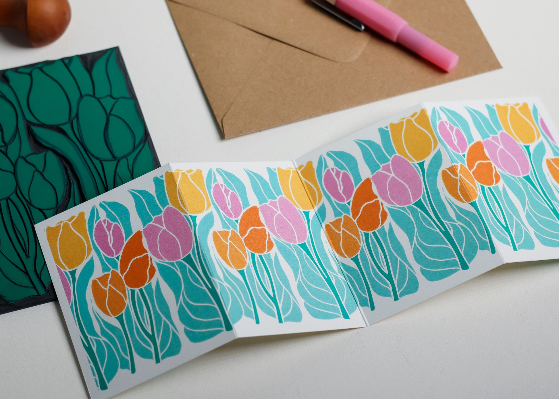 Floral card with colorful tulips on a white surface with stationery items.