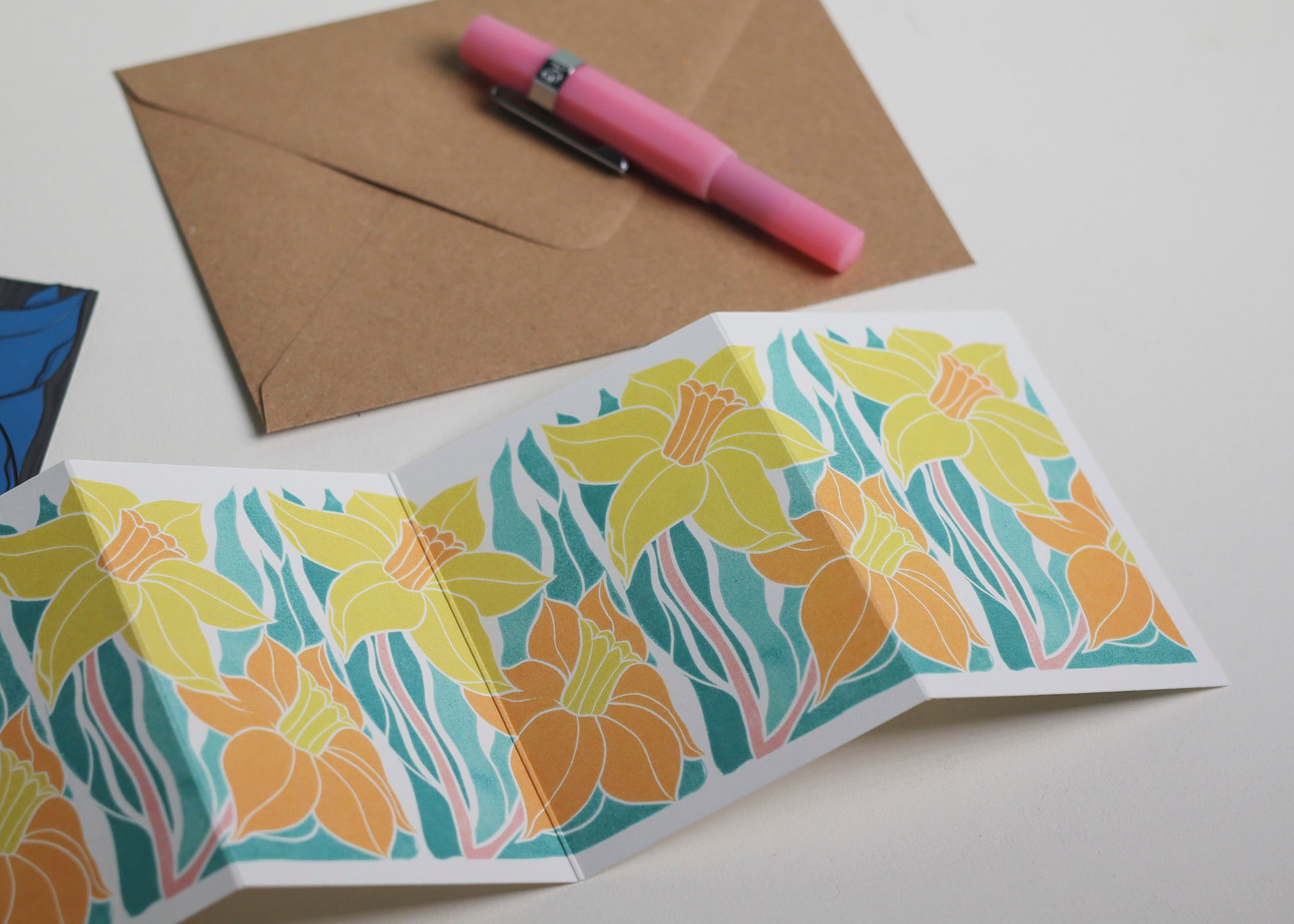 Welsh Daffodil Garland card with C6 kraft envelope. Hand-carved botanical portrait greeting card on recycled cardstock, photographed with eco-friendly envelope, ready for posting.
