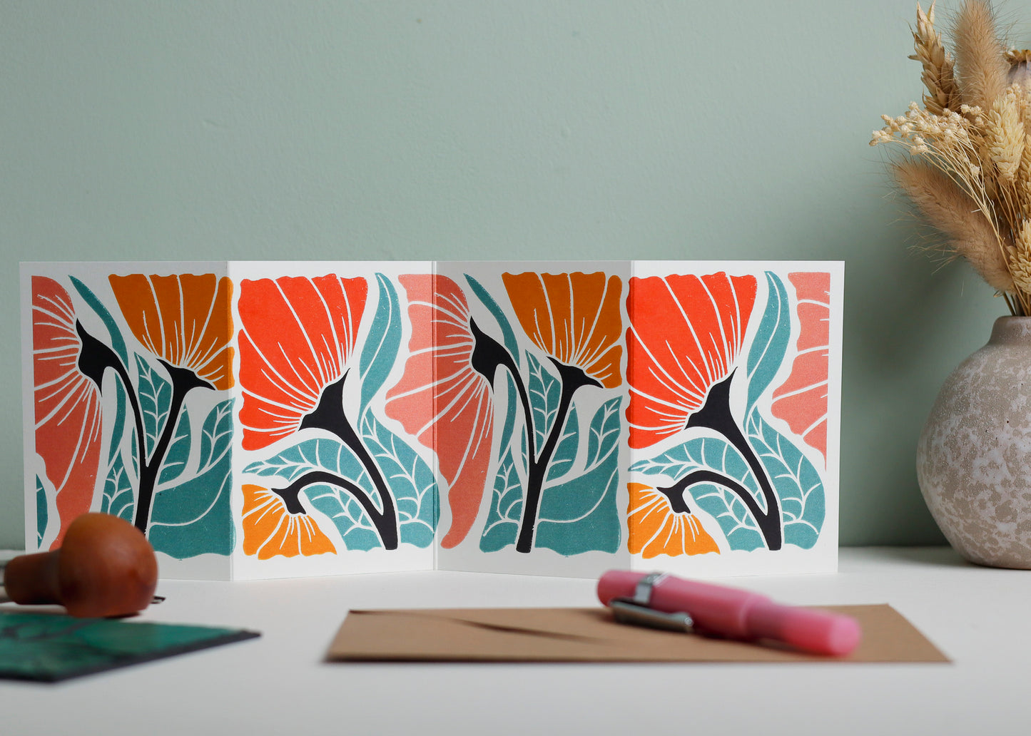 Happy Floral Garland card featuring hand-carved linocut botanical portrait in a contemporary red, pink and yellow palette. Double-sided concertina greeting card with bold, contemporary cottagecore design on eco-friendly recycled cardstock.