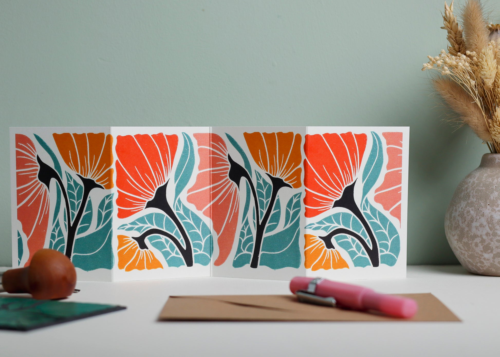 Happy Floral Garland card featuring hand-carved linocut botanical portrait in a contemporary red, pink and yellow palette. Double-sided concertina greeting card with bold, contemporary cottagecore design on eco-friendly recycled cardstock.