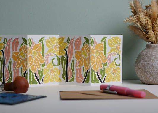 Daffodil Garland card featuring hand-carved linocut botanical portrait in yellow, green and pink. Double-sided concertina greeting card with bold, contemporary cottagecore design on eco-friendly recycled cardstock.