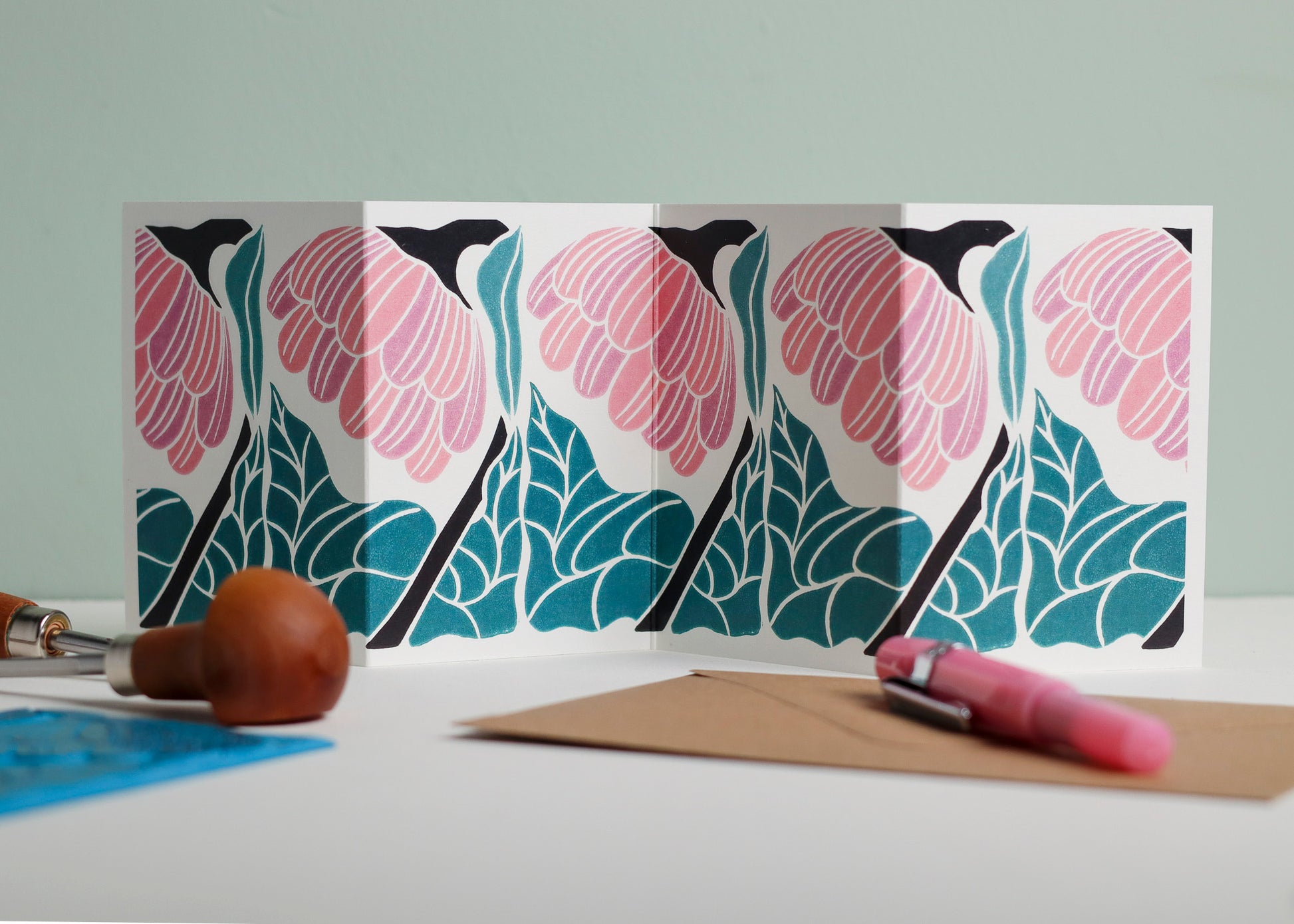 Reflection botanical Garland card shown fully extended (105 x 297mm), displaying complete hand-carved linocut design. Modern cottagecore flower portrait, perfect for mantlepiece display.