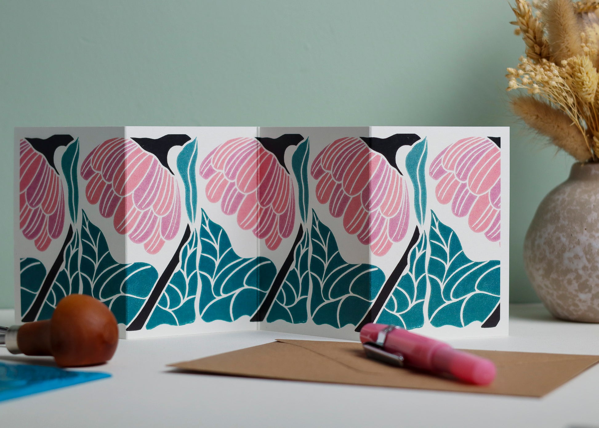 Reflection floral Garland card featuring hand-carved linocut botanical portrait in pink. Double-sided concertina greeting card with bold, contemporary cottagecore design on eco-friendly recycled cardstock.