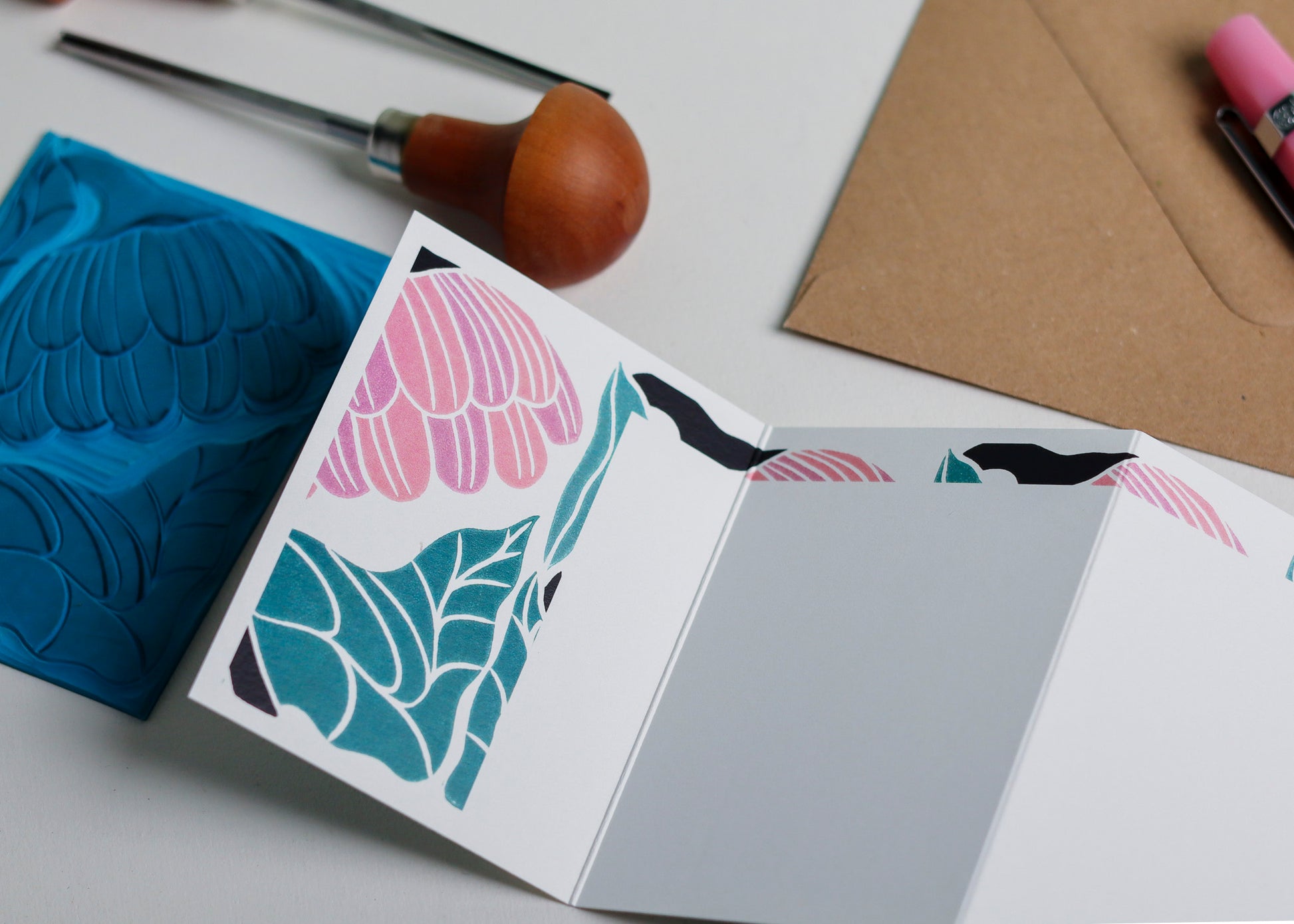 Reflection Garland card with original hand-carved lino block and carving tools. Relief printmaking process showing traditional linocut technique used to create botanical portrait. Real tools, real linoleum, handmade in Norfolk countryside studio.