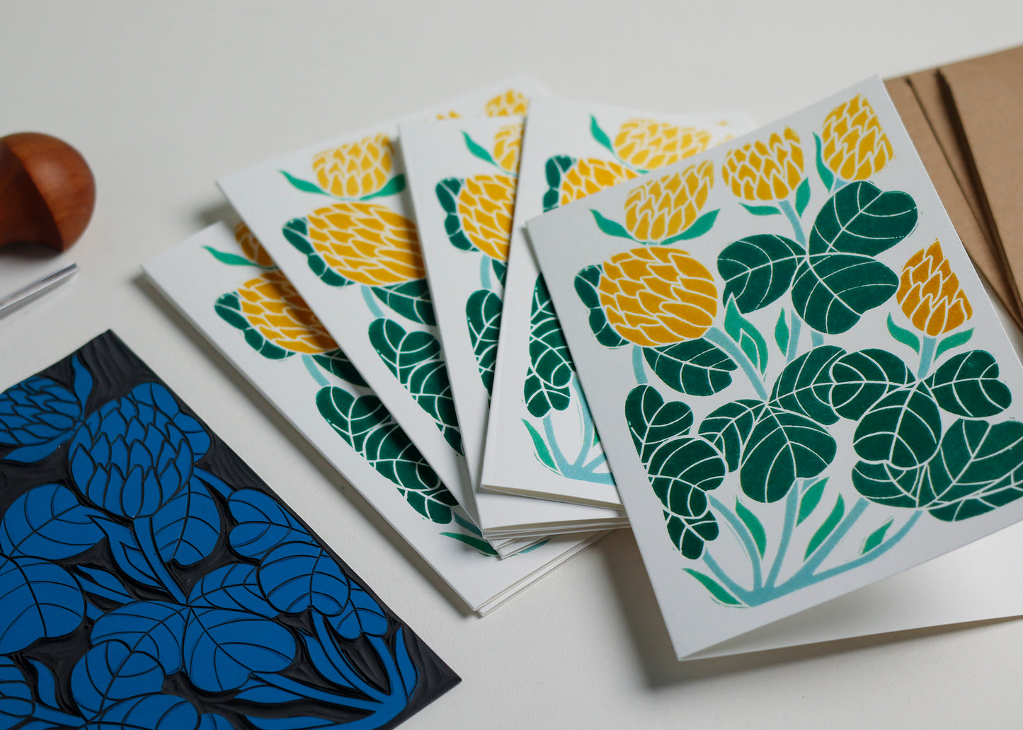 Set of 8 hand-carved botanical notecards featuring Ireland's national flower, the shamrock aka clover. A6 linocut print greeting cards in sunshine yellows, displayed with kraft envelopes. Cottagecore stationery on recycled cardstock.