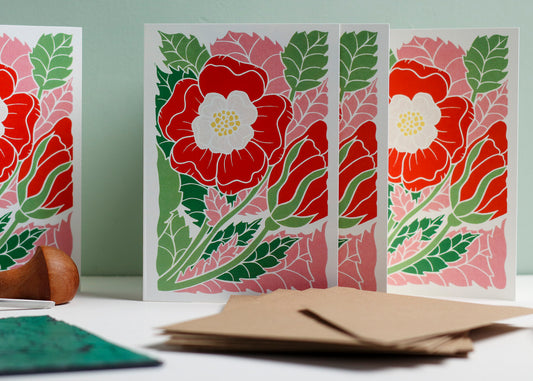 Set of 8 hand carved botanical notecards featuring the English Tudor rose. A6 linocut print greeting cards in eye-catching red and pink, displayed with kraft envelopes. Cottagecore stationery on recycled cardstock.