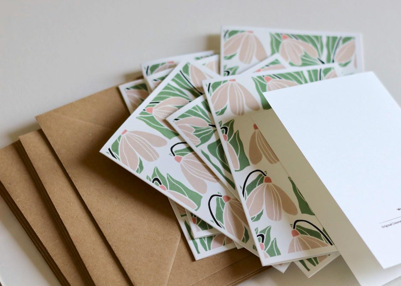 This set of note cards features a repeating winter snowdrop design in a soft green and off-white colour pattern.